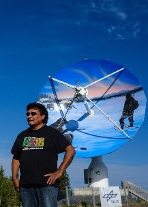 L’artiste gwich’in Ronnie Simon devant l’antenne du DLR (centre aérospatial allemand)